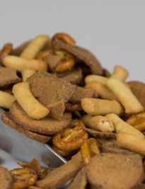 A scoop of Party Mix with Garlic Rye Chips, Pretzels and Bread Sticks