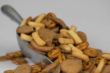 A scoop of Party Mix with Garlic Rye Chips, Pretzels and Bread Sticks