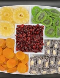 Dried fruit platter of pineapple rings, kiwi, cranberries, apricots, and date coconut rolls