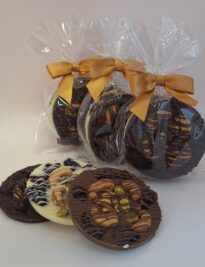 Chocolate discs topped with pistachios, cashews and cranberries