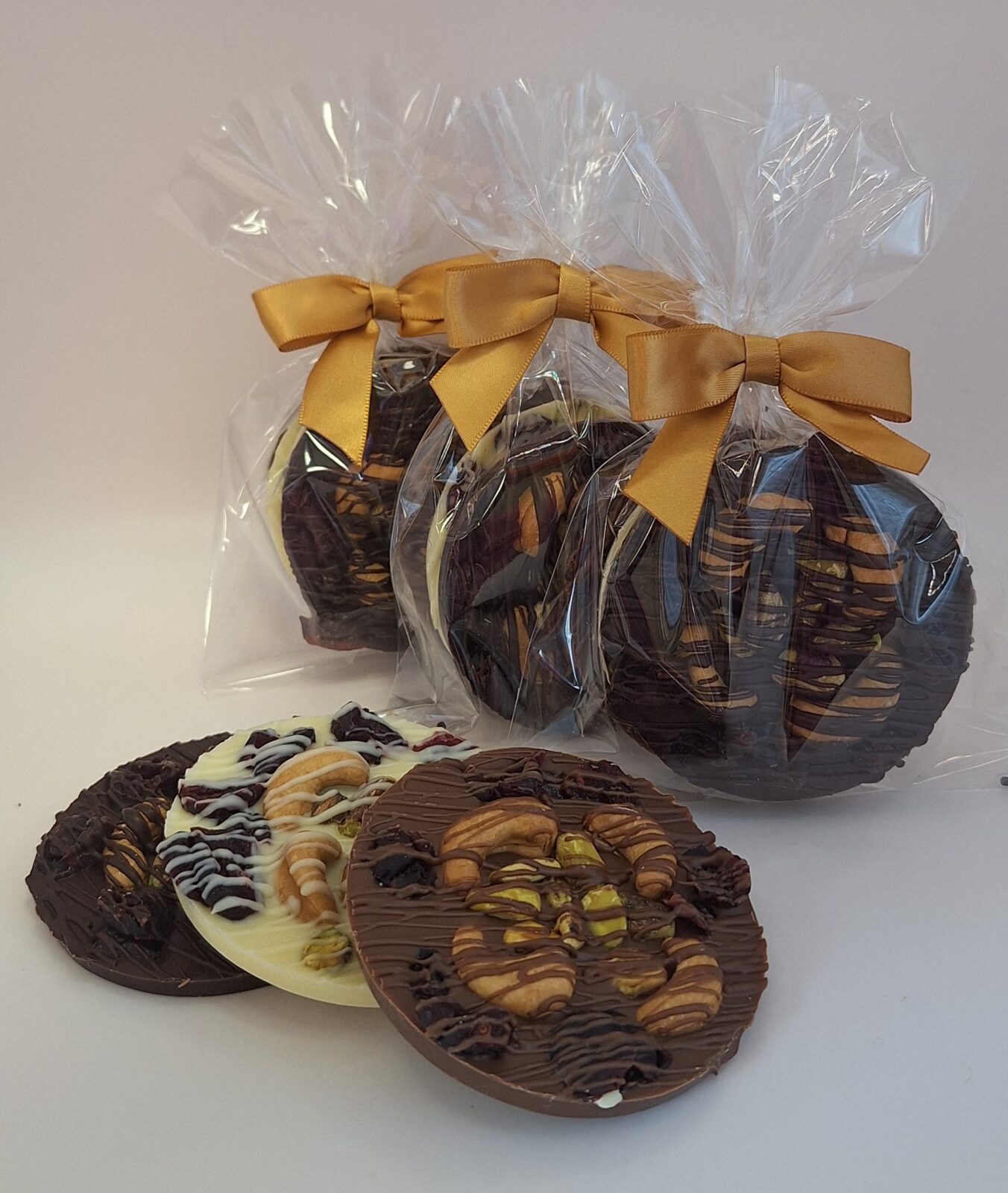 Chocolate discs topped with pistachios, cashews and cranberries
