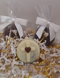 Three cross Oreos with bows displayed on decorative gold and white crinkle