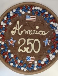chocolate pizza with red, white and blue chocolate gems and the words America 250