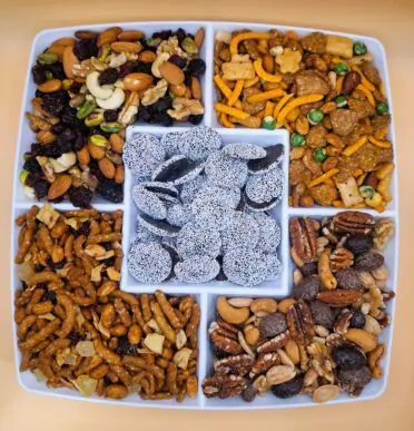 Tray of trail, nut and snack mixes with dark chocolate nonpareils in the center
